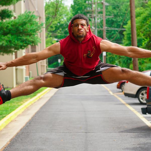 A focused man in athletic wear performing a flexibility exercise.